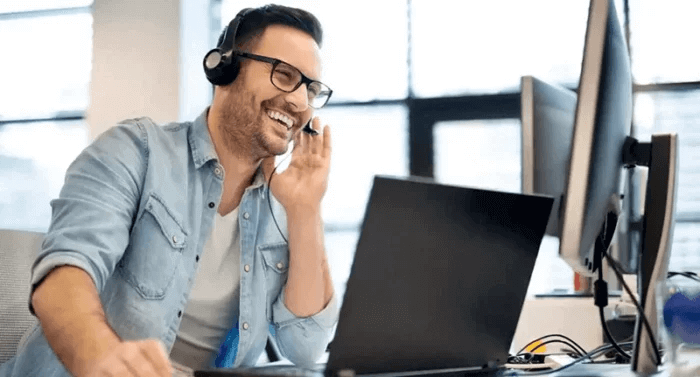 A happy customer support agent wearing headphones, answering client inquiries about language courses