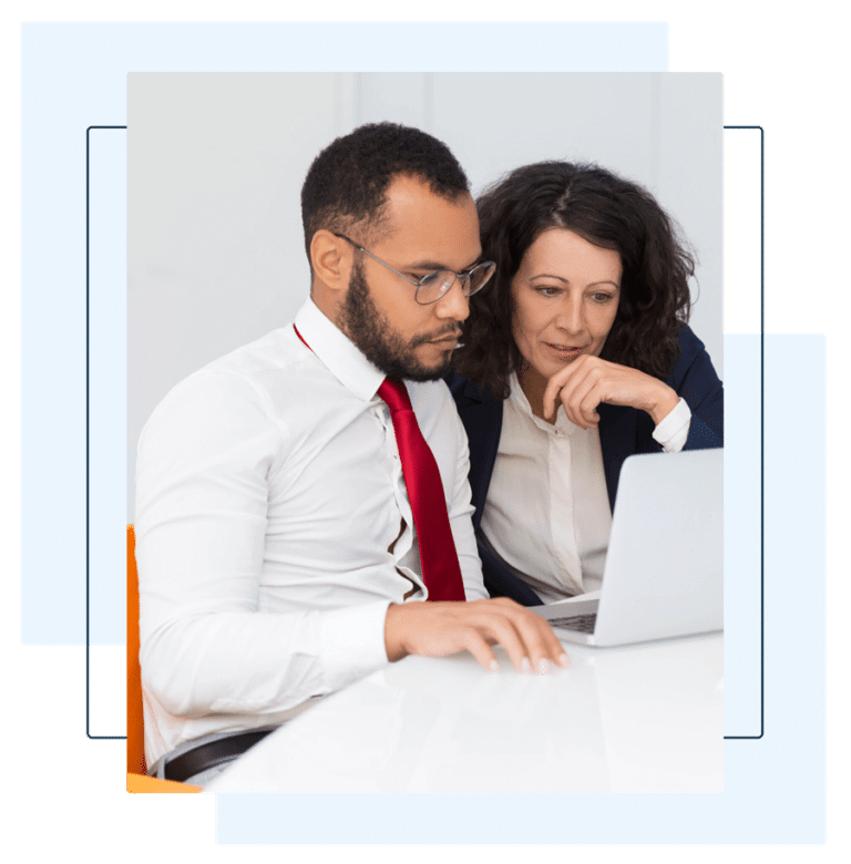 A business professional and an instructor collaborating while looking at a laptop in a modern office setting. This image highlights the interactive and flexible learning experience offered by online Arabic courses, designed to meet the needs of professionals and organizations.