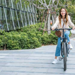 Jeune femme souriante à vélo, représentant la satisfaction après avoir suivi un cours d’espagnol en ligne interactif.
