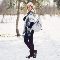 Jeune femme se promenant dans la neige, représentant une pause après un cours d'espagnol en ligne interactif.