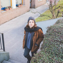 Jeune femme montant des escaliers dans un cadre urbain après avoir suivi un cours de français en ligne avec Edlingo.