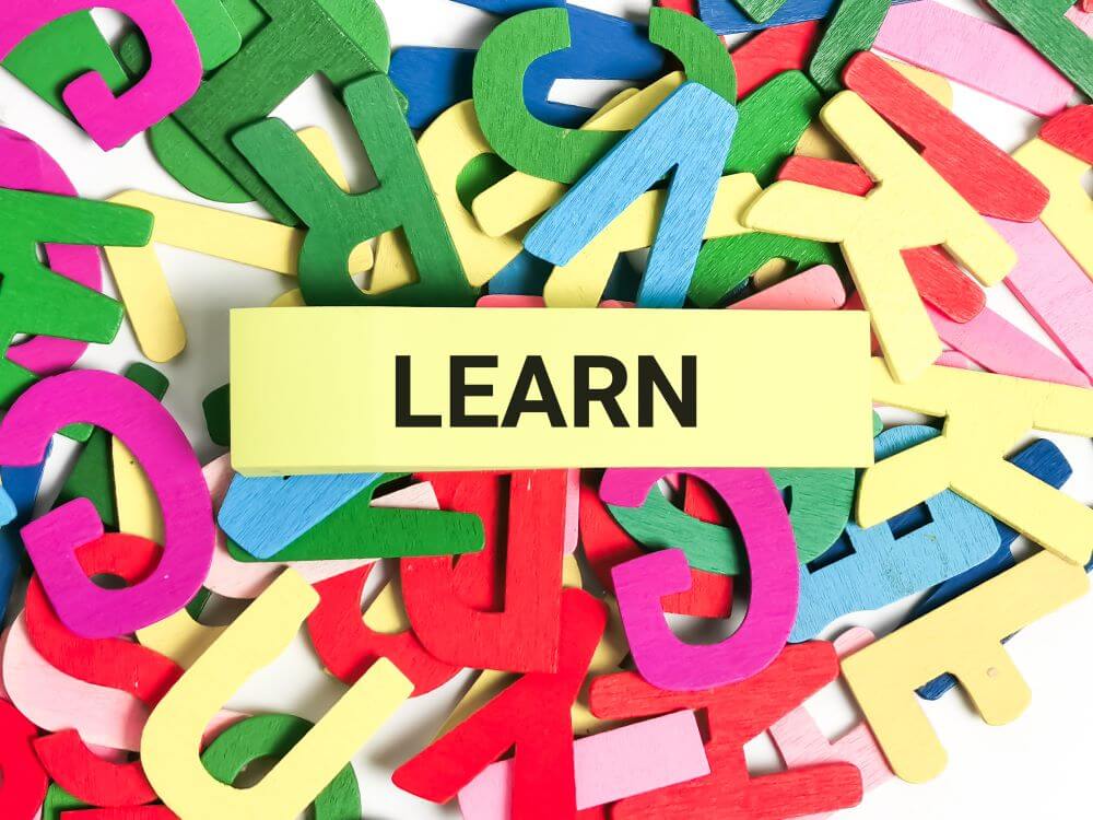 Lettres colorées en bois avec le mot learn, symbolisant l'apprentissage des langues