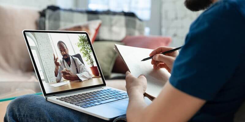 Étudiant suivant un cours en ligne pour apprendre la grammaire anglaise avec un professeur.